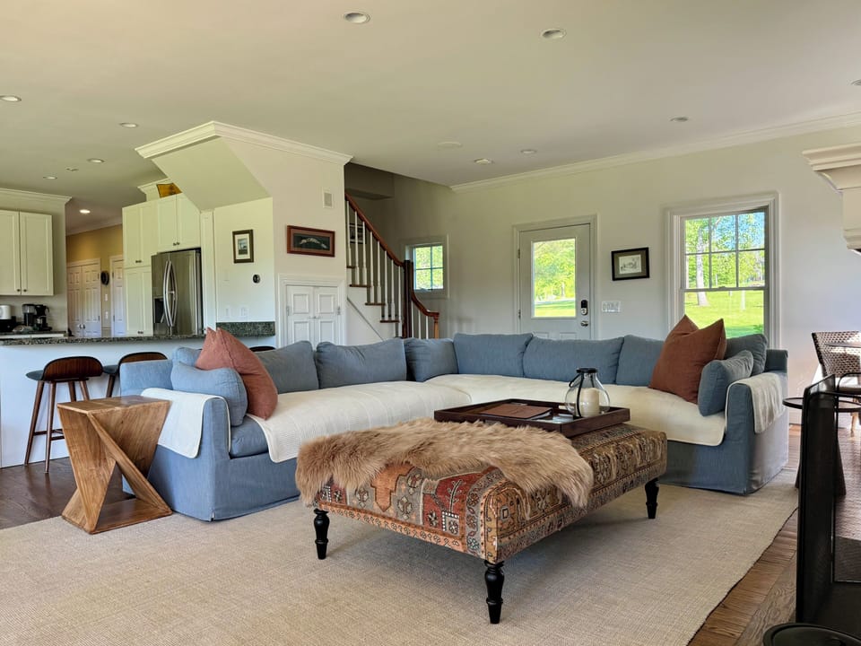 Open living room with comfy seating for six, central TV, and views