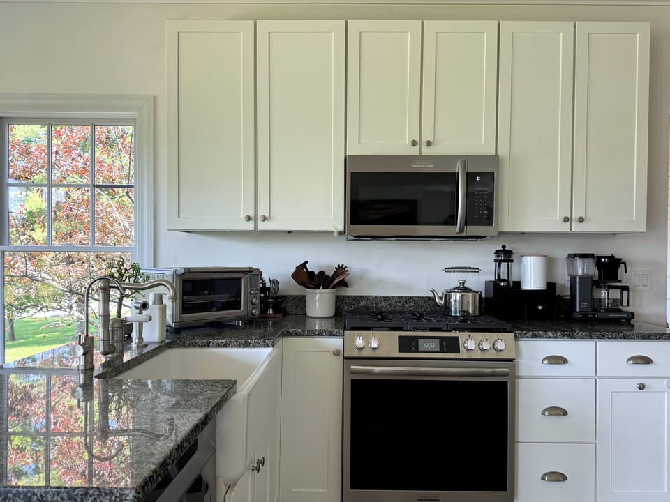 Kitchen with stainless appliances, granite counters, and farmhouse sink.