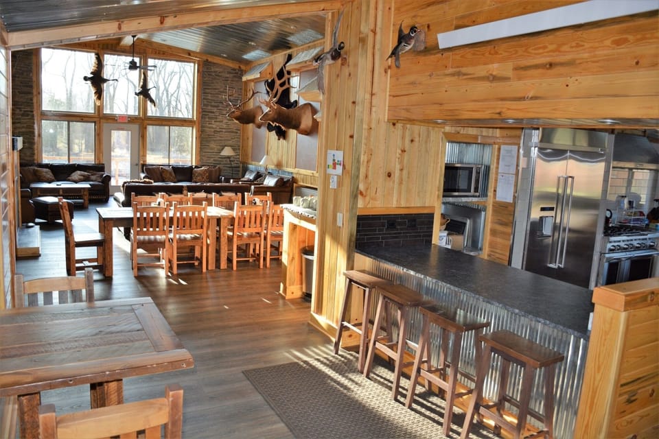 Bar with 3 barstools looking into kitchen, as well as small table for 2, with views to the south.