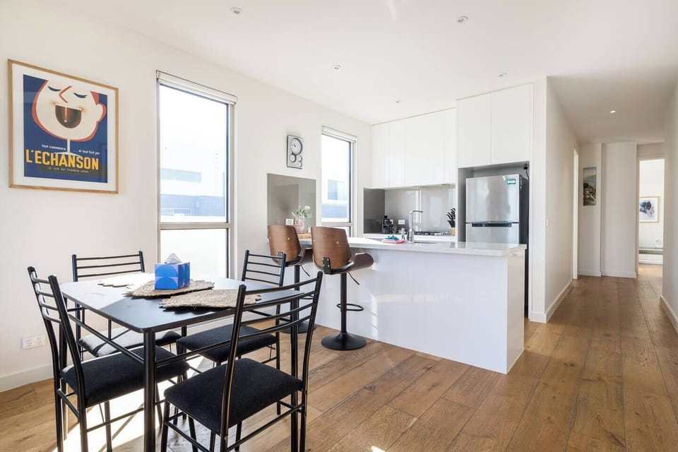 The light-filled dining area offers a four-seater table to enjoy meals together, with additional seating available at the breakfast bar. 
