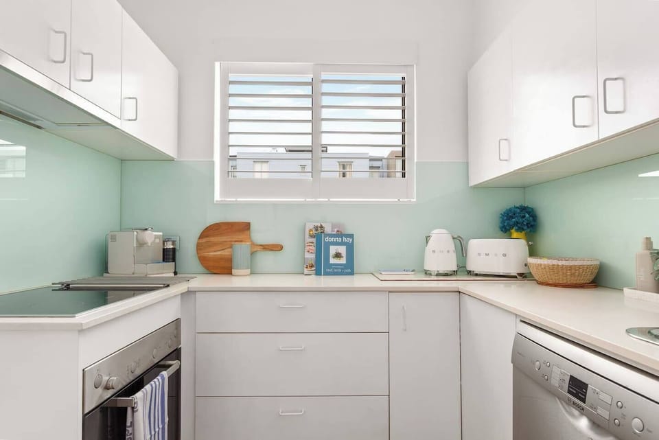 The kitchen is fully equipped to prepare meals at home on sleek appliances and cooking utensils.

