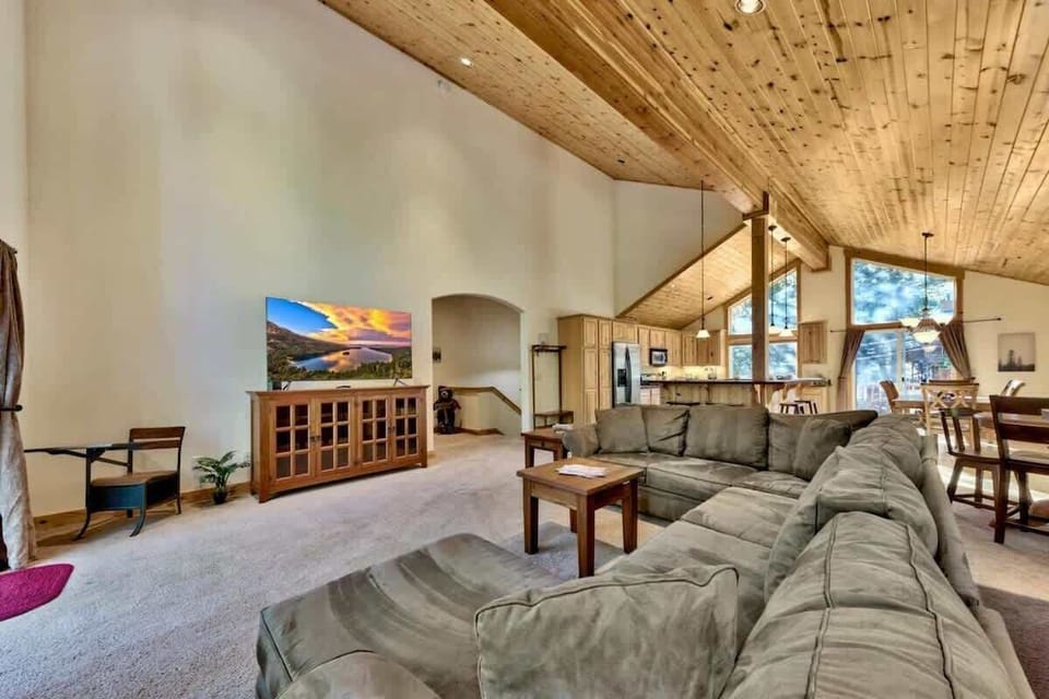 Large Tahoe cabin living area with Smart TV, fireplace and comfortable seating, providing an inviting space for families and groups to relax and enjoy movie nights.
