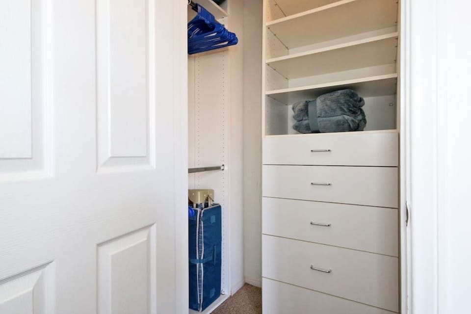 Primary Suite 1: Walk in closet with pack and play, extra blankets, iron, ironing board, and plenty of hangers. 