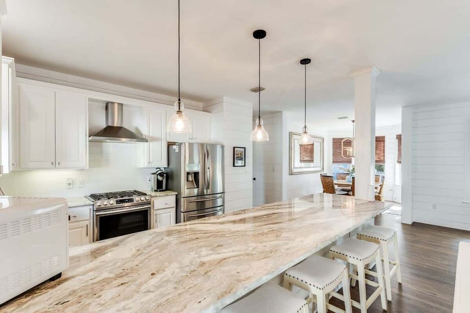 - Whip up coastal feasts in this chef ready kitchen featuring sleek stainless steel appliances - Gather around the long granite island for cocktails, snacks, or a hearty breakfast - Open layout means no one misses out on the conversation and fun