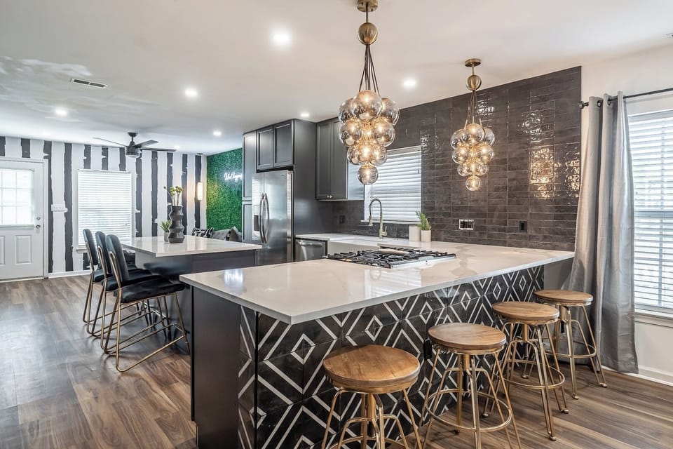 Come see it for yourself: designer kitchen with unique lighting, large island, and perfect to whip up a nice home cooked meal...or hire a chef! ‍ 