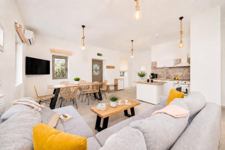 Open-plan living room with sofa, dining area, kitchen, A/C, WiFi internet, and satellite TV