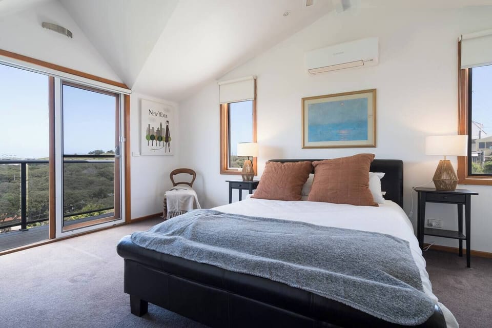 Sleep easy within the primary bedroom. It highlights a queen-sized bed and beautiful views.