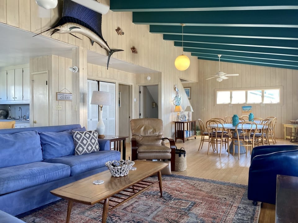 Relax in your coastal retreat with ocean-blue sofas and nautical charm, where maritime decor meets modern comfort in this open living space.