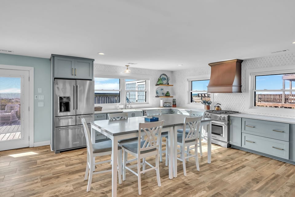Cook and dine in your bright, coastal-inspired kitchen with modern appliances and stunning water views through every window.