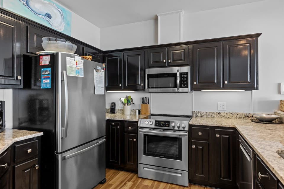 Your gourmet kitchen features stainless steel appliances, granite counters, and rich dark cabinetry - perfect for preparing memorable meals.