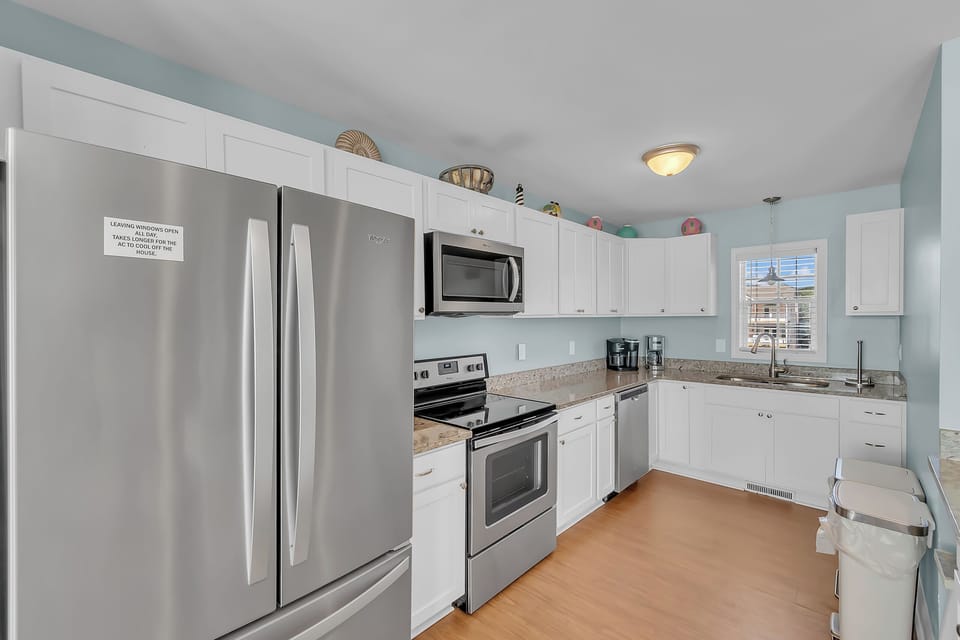 Your fully equipped kitchen awaits with stainless steel appliances, granite counters, and warm coastal colors for memorable meal prep.