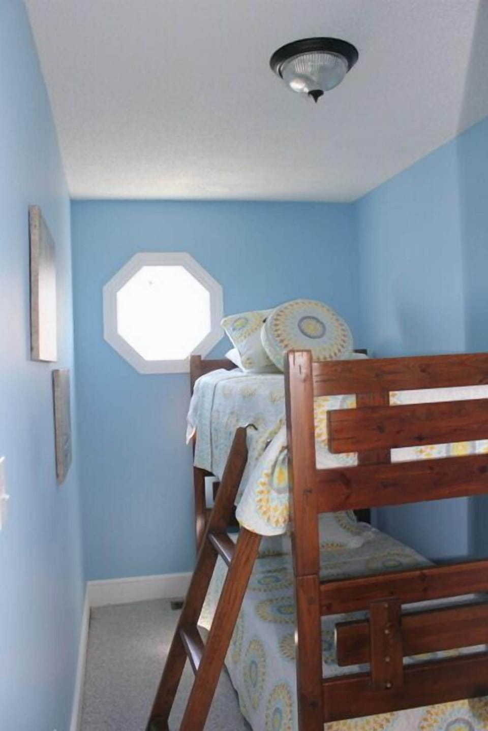 Your kids will love this cheerful bunk bed room with its soothing blue walls and bright natural light from the octagonal window.