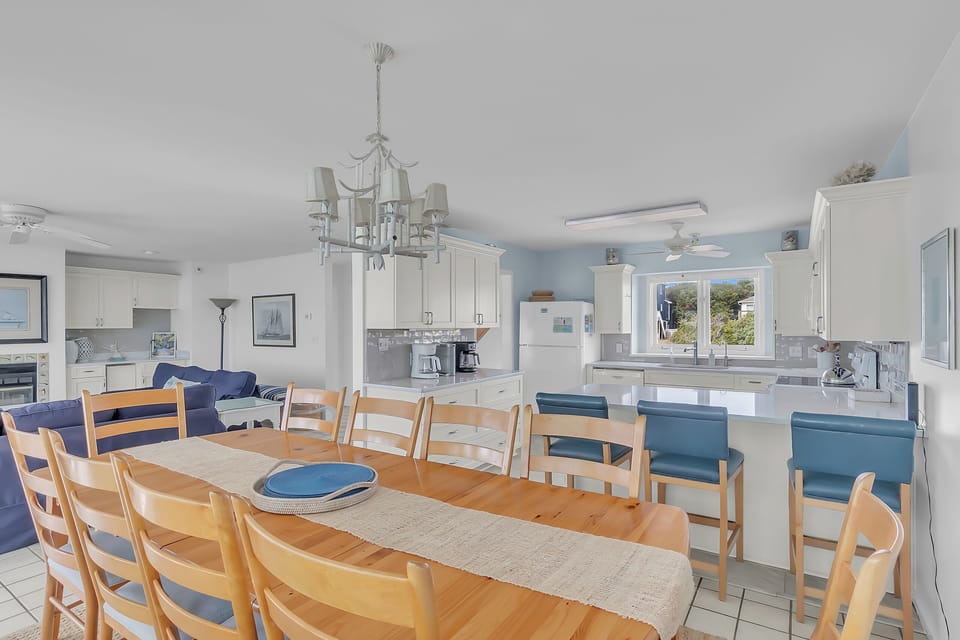 Gather around this spacious dining table where your group can share memorable meals together, with a fully equipped kitchen ready for your culinary adventures.