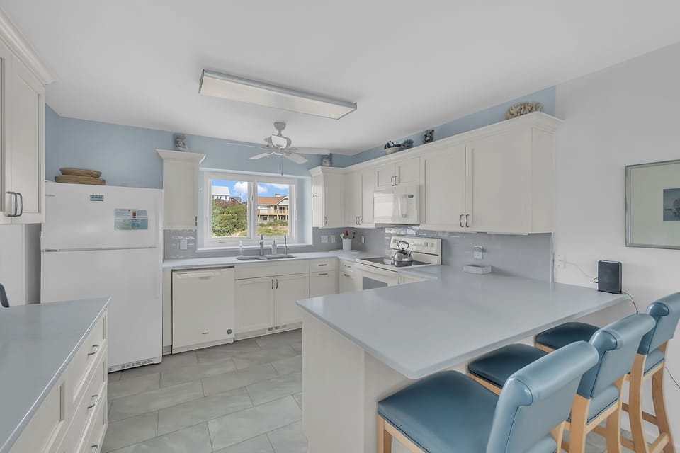 Your spacious kitchen awaits with modern appliances, granite counters, and bright island seating perfect for morning coffee or casual meals together.