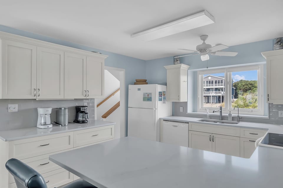 Your fully equipped kitchen features white cabinetry, granite counters, and all appliances needed for home-cooked meals with lovely water views.
