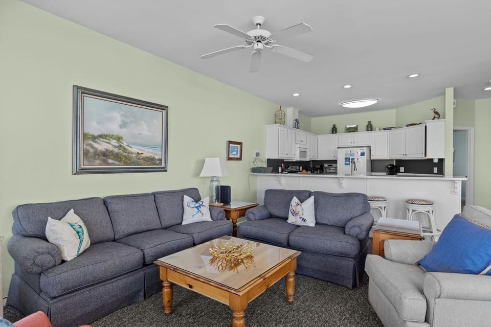 Unwind in your spacious living room where coastal charm meets comfort with plush seating and open kitchen perfect for gathering.