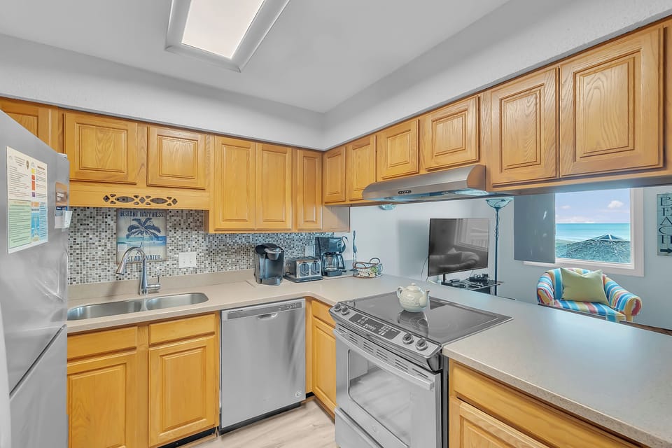 Your fully-equipped kitchen features modern stainless steel appliances and warm wood cabinets, with stunning ocean views to inspire your culinary adventures.
