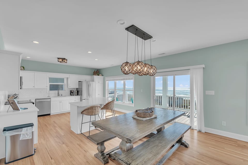 Your bright kitchen and dining space opens to stunning ocean views through sliding doors, perfect for memorable meals.