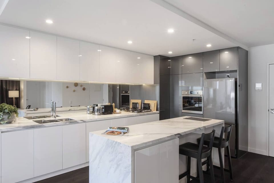 The modern, marble-topped kitchen is fully equipped for home-cooked feasts and quick bites at the breakfast bar.