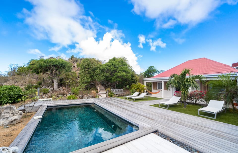 Lounge chairs, sofa, heated infinity pool, stereo sound system. Outdoor living room under a gazebo, with a dinning table for eight people. 