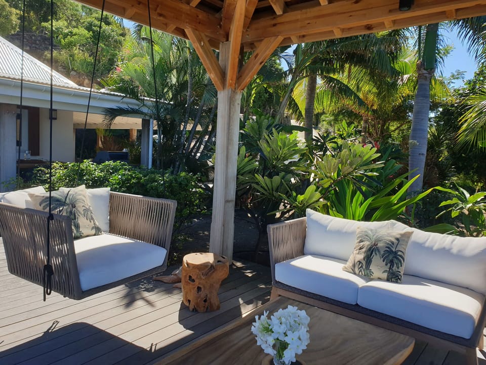 Nice lounge on the covered terrace and under an ajoupa. Outdoor wooden dining table for 8 people. 