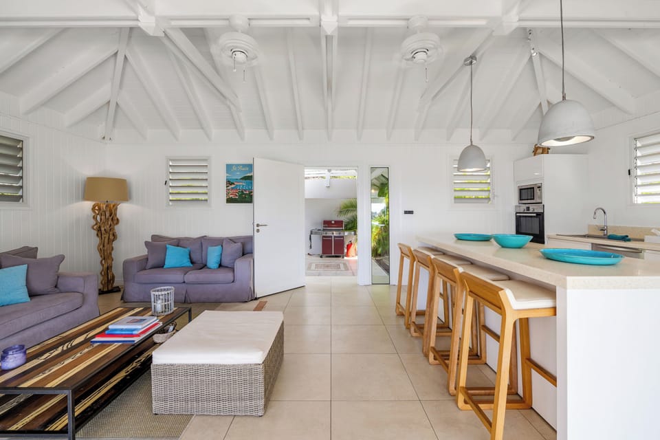 Fully-equipped kitchen, separated from the living area by a breakfast bar. Blender, coffee maker, dishwasher, freezer, ice maker, microwave, Nespresso coffee machine, oven, refrigerator, toaster. Dining table on the covered terrace, next to an outdoor lou