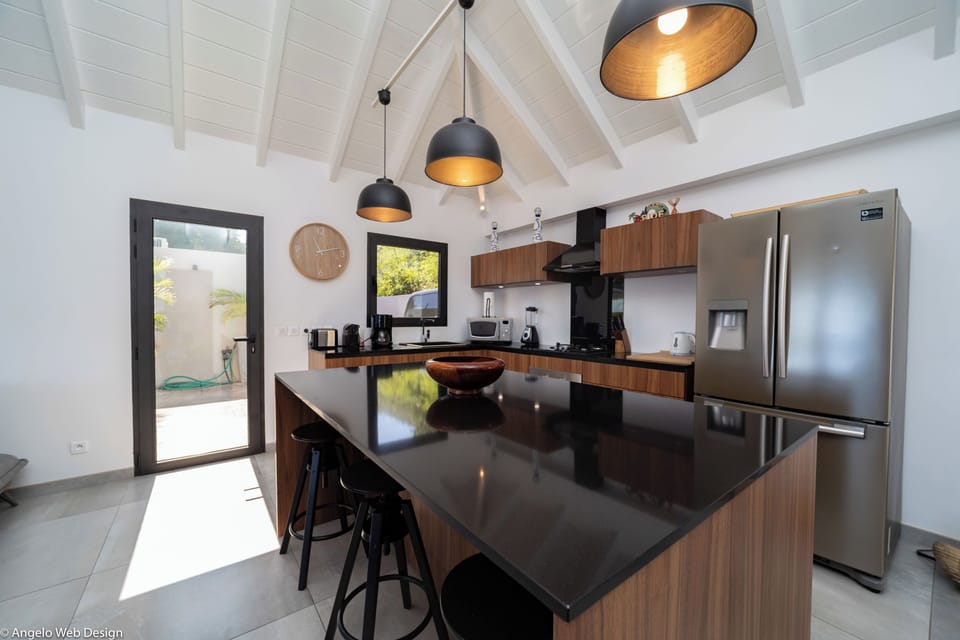 Modern kitchen equipped with a breakfast bar, electric oven, gas stove, fridge and freezer with ice maker, dishwasher, microwave, toaster, Nespresso coffee machine, blender, hood, electric kettle. Dining table for 6 people on the covered terrace. 