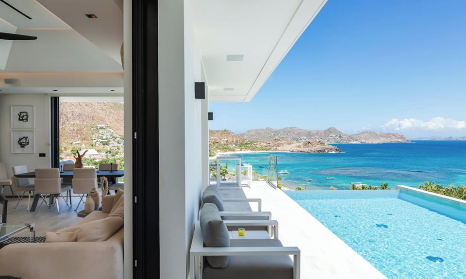 Large heated lap pool on the main level with steps. Expansive terrace, confortable ratten seatings. 