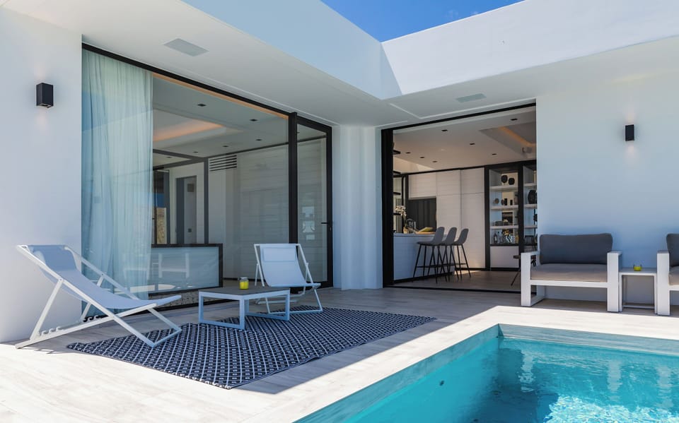Large heated lap pool on the main level with steps. Expansive terrace, confortable ratten seatings. 