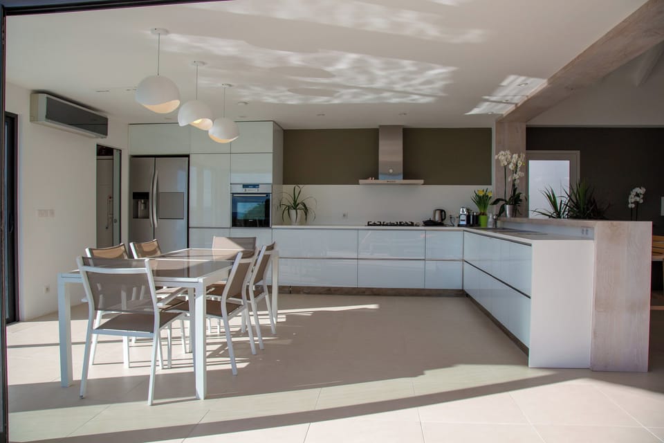 Air-conditioned, fully equipped kitchen. Oven, microwave oven, mixer, blender, refrigerator, freezer, ice machine, dishwasher, citrus press, Nespresso coffee machine, kettle, toaster. Wine cellar. Dining table with four chairs.