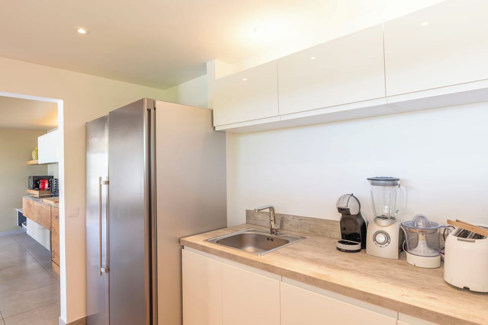 Modern, and fully equipped kitchen. Coffee machine, dishwasher, espresso machine, gas cooker, microwave oven, oven. Dining area for 6 people, facing the view. Ceiling fans. A second dining area for 6 people is located next to the great room, opening onto 
