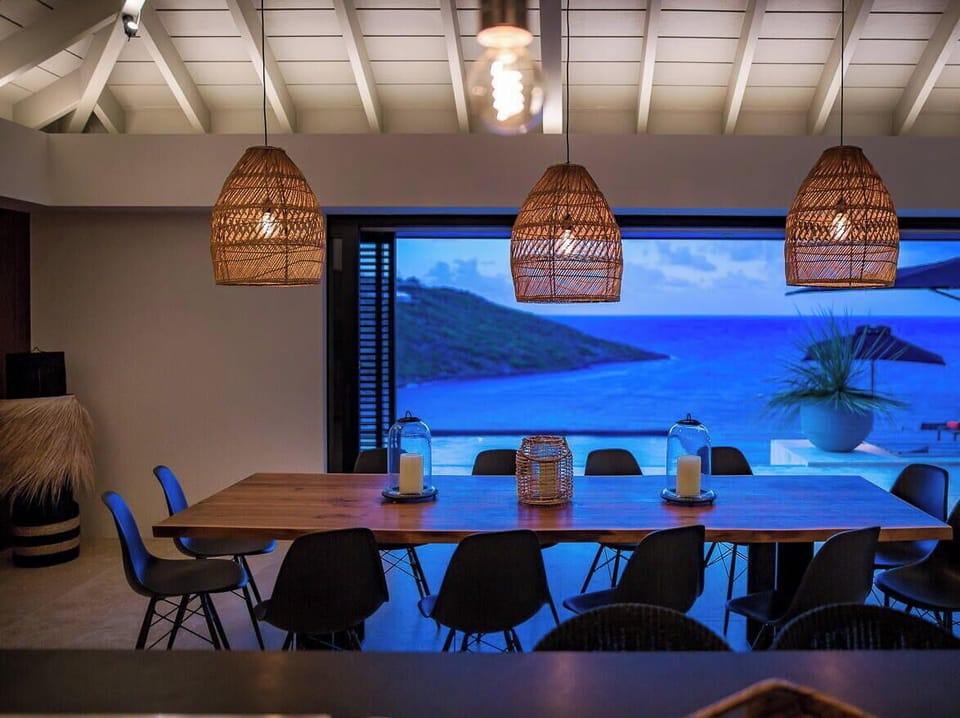 Indoor dining area with dining table for twelve people. Outdoor dining area near the pool, sofas and a rectangular wooden table covered with a parasol. Breathtaking views. 