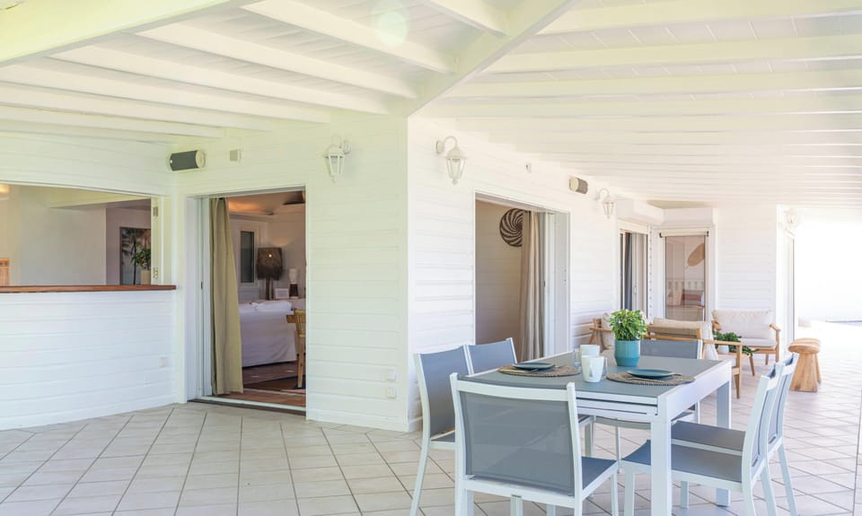 Open-air fully equipped kitchen. Electric oven, gas stove, microwave, refrigerator, mixer, freezer, dishwasher, Nespresso machine, blender, kettle, toaster, breakfast bar. Indoor dining table and dining area on the covered terrace. 