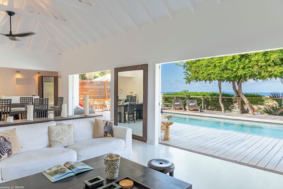 Living room with very comfortable white sofas. Ceiling fan, DVD player, HD-TV, Dish Network, Apple TV. Opens onto the pool and the terrace with a panoramic view over Gustavia. 