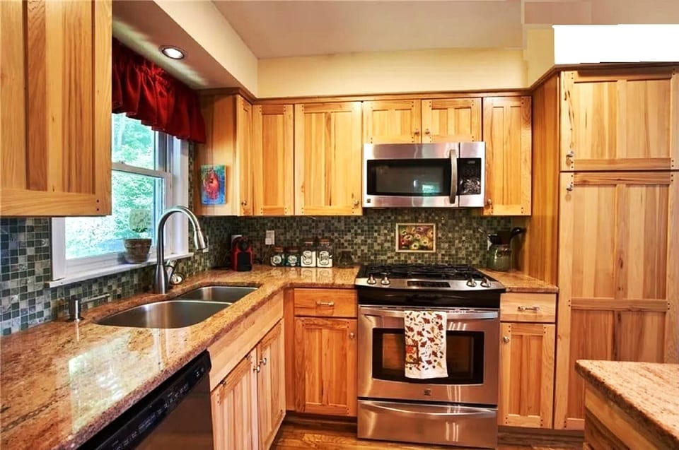 The modern kitchen is well-supplied, featuring a gas range and granite counters.