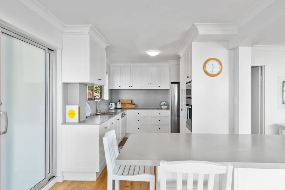 A gorgeous contemporary kitchen comes fully equipped for your holiday cantering with sleek appliances and cooking utensils.
