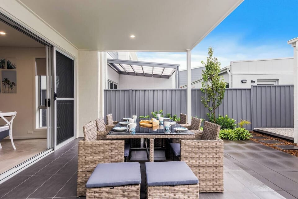 The downstairs living area opens out to an outdoor patio, complete with an eight-seater table setting and BBQ grill. 