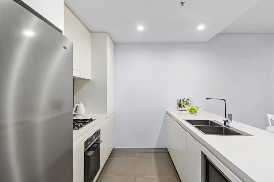 The kitchen neatly tucks away appliances, with the microwave discreetly in the island benchtop and the oven flush under the stove. 
