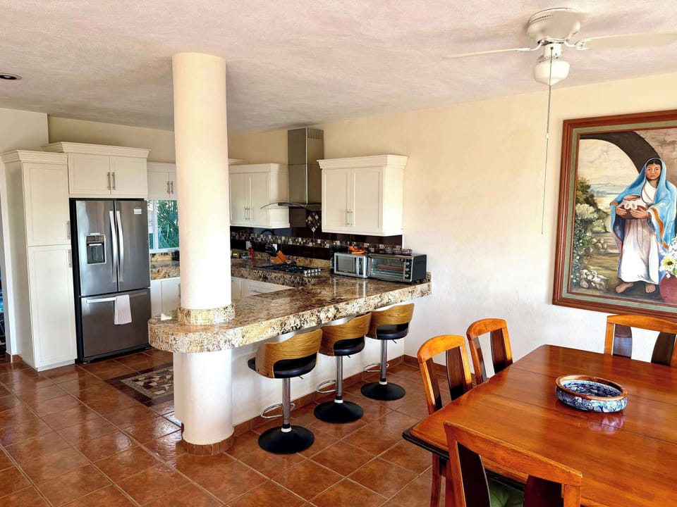 Kitchen with bar seating and large dining room table that seats 8 people.