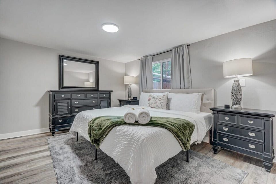 Experience Ultimate Comfort with a King Size Bed, Soft Bedside Lamps, Luxurious Linens, a Chic Mirror, and a Window to Welcome the Day's Light