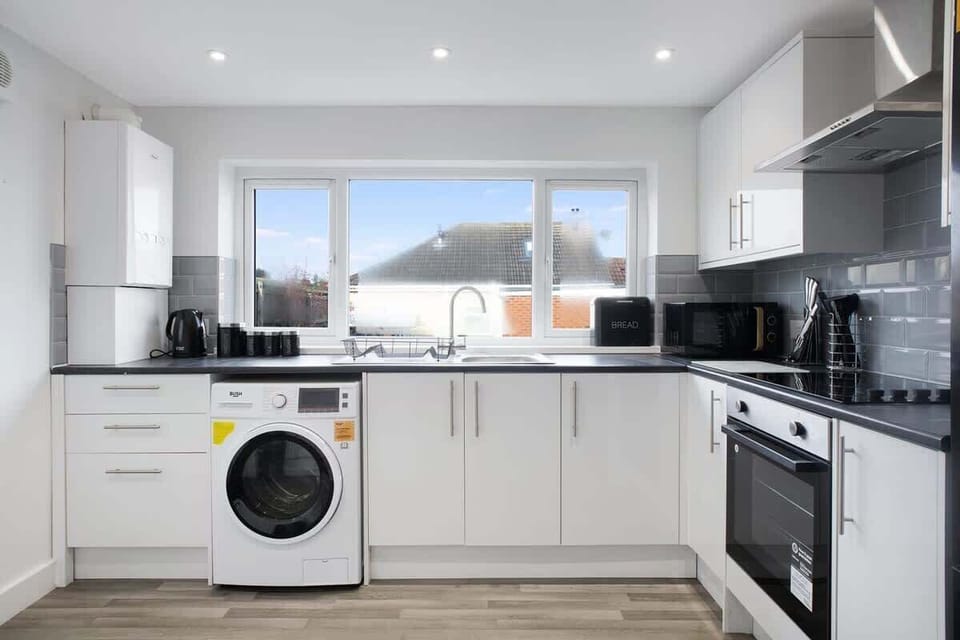 Kitchen equipped with all essentials, including a washer & dryer, oven, fridge and full cookware set.