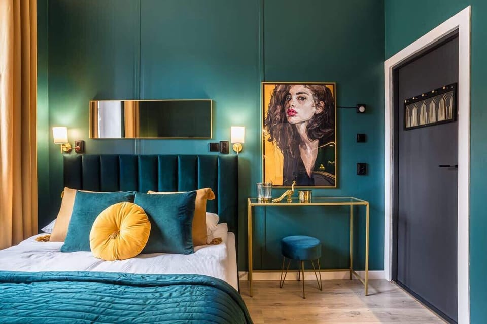 Another view of the bedroom, highlighting the bed, wall art, and gold details.

