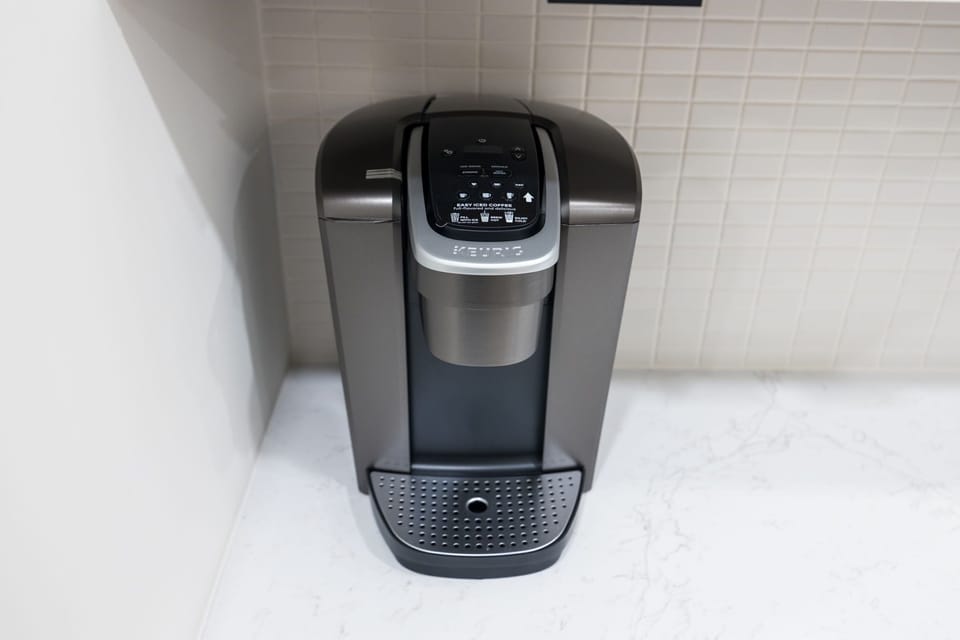 Fully equipped kitchen boasting brand-new stainless-steel appliances and a large island with bar seating stocked with all culinary essentials for ease and convenience during your stay.