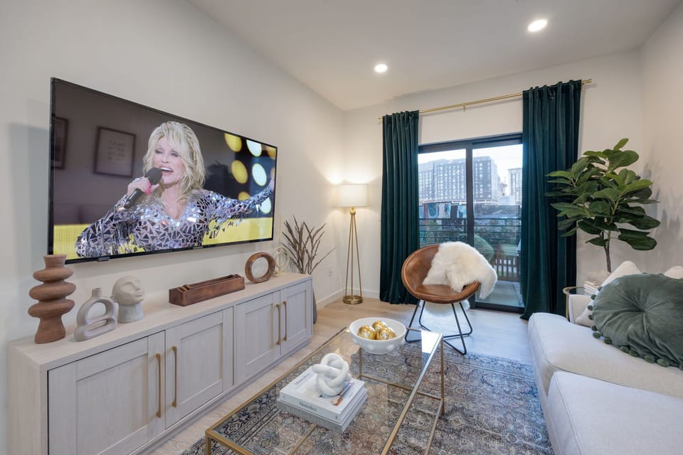 Bright and modern living room featuring a Smart TV, and comfortable living room furnishings to unwind after a long day accompanied by a private balcony.