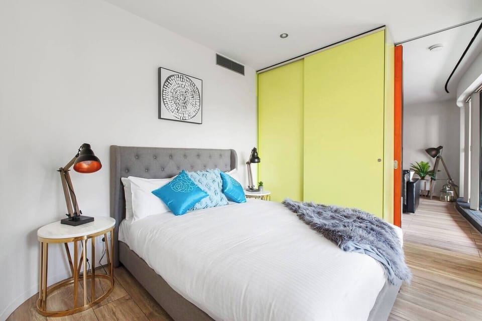 A second room has a plush queen bed, bedside tables and built-in wardrobes, and is decorated in fun pops of colour