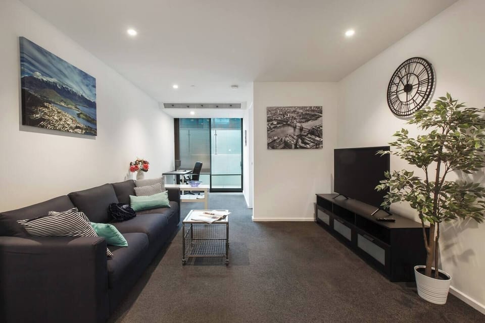A spacious living area comes furnished with a plush, three-seater sofa that sits opposite a 46" Smart TV