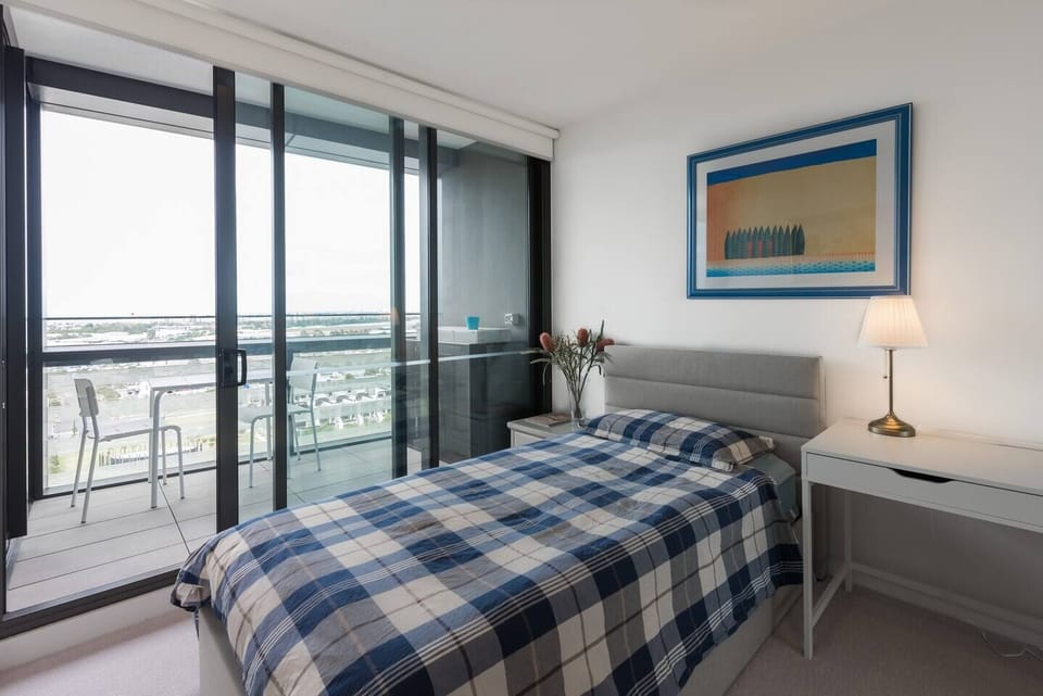 A second bedroom sleeps one in a single bed and has a built-in wardrobe, bedside tables, a study desk with a chair and lamp and the luxury of a cozy private balcony
