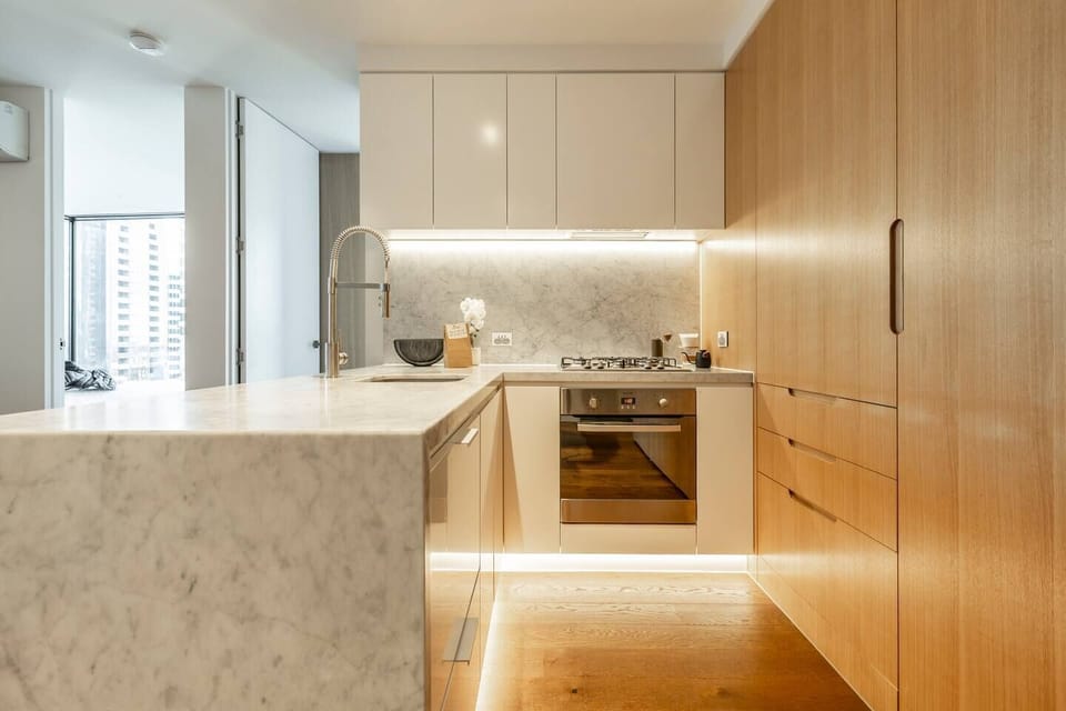 Marble benchtops, premium appliances and chic timber cabinetry make this kitchen the ideal place to cook up a storm on your nights in