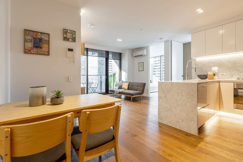 The bright living area sits alongside a dining table for four and a stylish, open-plan kitchen fit will premium appliances