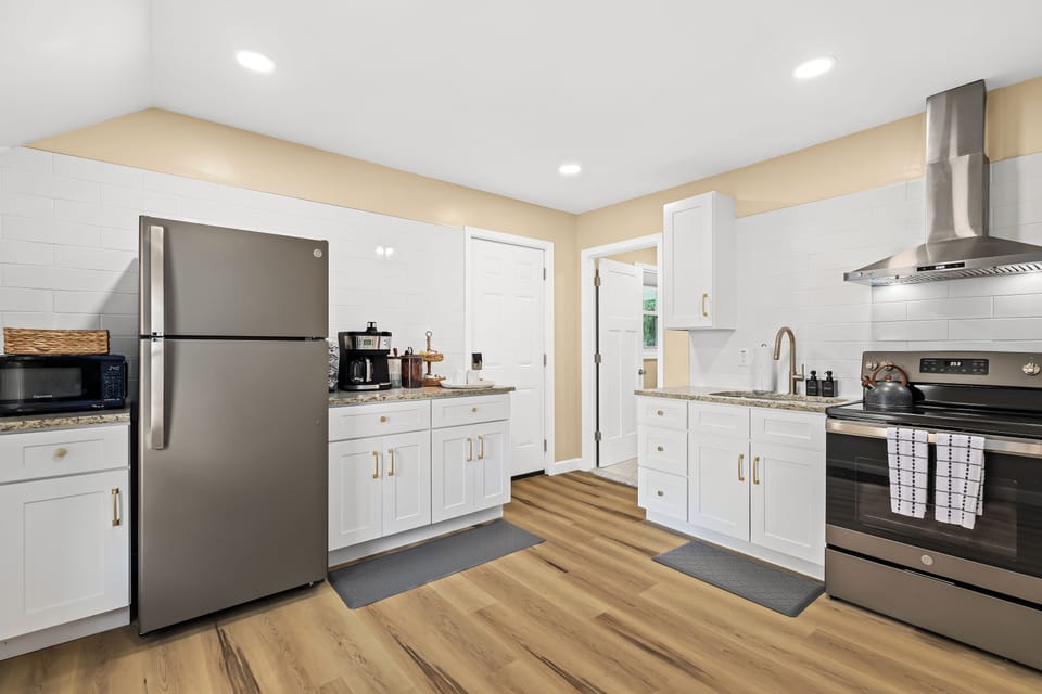 This kitchen is fully equipped with a stove, oven, sink, and refrigerator. There is also a microwave, toaster, and coffee maker.